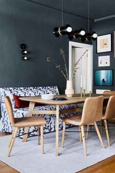 a dining room table with chairs and pictures on the wall above it, along with other furniture