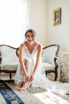 a woman sitting on top of a rug next to a chair