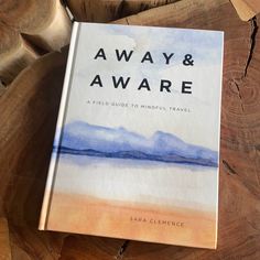 a book sitting on top of a wooden table next to a piece of driftwood