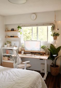 a bedroom with a bed, desk and computer on the window sill in it