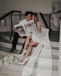 a bride and groom are sitting on the stairs