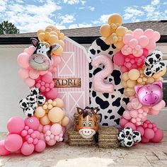 an animal themed birthday party with farm animals and balloons in front of a barn door