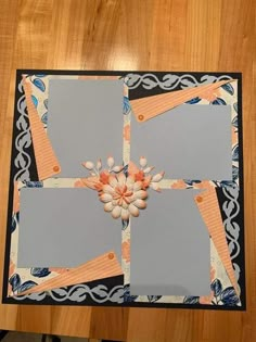 an altered photo frame with flowers and leaves on the edges, sitting on top of a wooden table