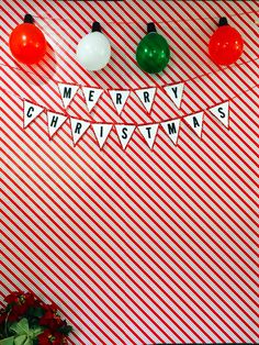 christmas decorations are hanging on a red and white striped wall