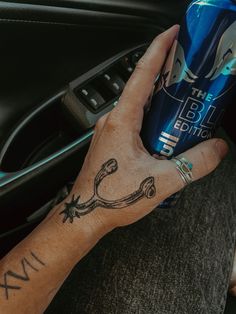 a person with a tattoo on their arm holding a can