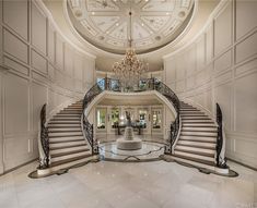 a large foyer with stairs and chandelier