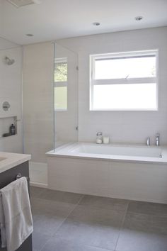 a bathroom with a tub, sink and mirror