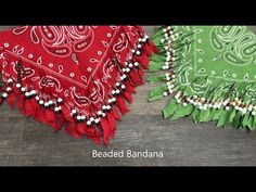 two red and green bandannas sitting next to each other on a wooden table