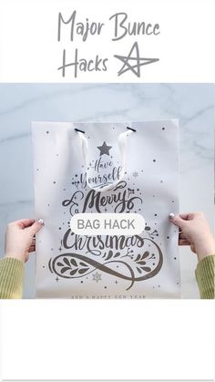 two hands holding up a paper bag with lettering on it and the words merry christmas