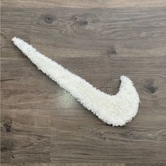 a white nike logo on a wood floor