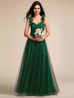 a woman in a green dress holding flowers