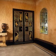 a room with a chair, mirror and vase on the floor in front of it