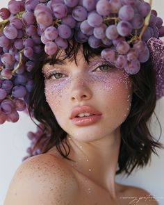 a woman with grapes on her head and water all over her face, posing for the camera