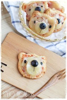 small pizzas with blueberries and cheese are on a wooden cutting board next to a basket