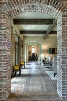 an old brick building with wood floors and arches in the center, leading to a living room