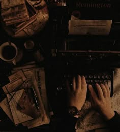 a person typing on an old typewriter surrounded by papers and other items that are scattered around