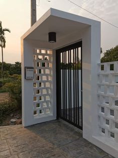 an entrance to a white building with bars on the door and gated in area