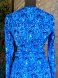 "Gorgeous vintage pre-loved dress from the 60's Bright colors on several blue tone, turquoise, celeste, skyblue Golden buttons with KS logo, long sleeves with 1 golden button, skinny belt made with the same fabric. Great vintage condition, no visible defects, pre-loved MATERIAL label says Ban-Lon (an hight quality nylon, silk touch) BRAND Ken Scott SIZE small/ M Vintage 10 (please refers on measures above) Approx measures taken flat shoulder cm 36 chest cm 43 Waist line cm 42 Hipsline cm 49 hem Fitted Abstract Print Top For Party, Retro Fitted Blue Tops, Vibrant Print Party Top, Fitted Blue Dress With Bold Print, Blue Long Sleeve Tops With Retro Print, Retro Blue Tops With Retro Print, Blue Retro Tops With Retro Print, Blue Fitted Retro Dress, Blue Long Sleeve Top With Retro Print