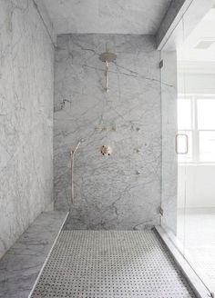 a bathroom with marble walls and flooring in the shower area is featured on instagram