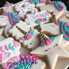 decorated cookies with unicorns and stars are on a plate in front of the camera