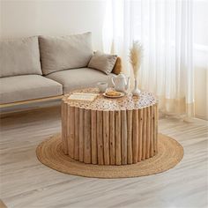 a living room with a couch, coffee table and rug on the floor in front of a window