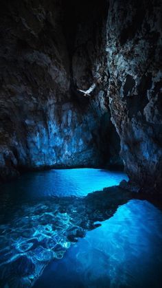 a cave with blue water in the middle