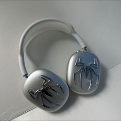 two silver headphones with spiderman designs on them