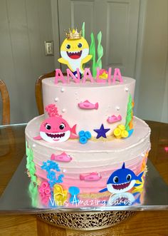 a birthday cake with pink frosting and colorful decorations