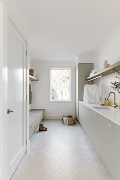 an empty kitchen with white cabinets and wood flooring