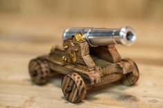 a small wooden toy car sitting on top of a wooden table next to a metal object