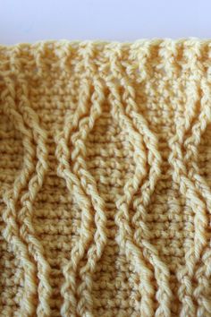 a close up view of a crocheted blanket with wavy lines on the edges