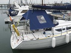 the sailboat is docked at the dock with other boats in the water behind it