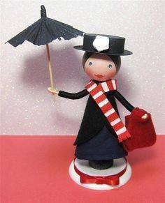 a small doll holding an umbrella on top of a table