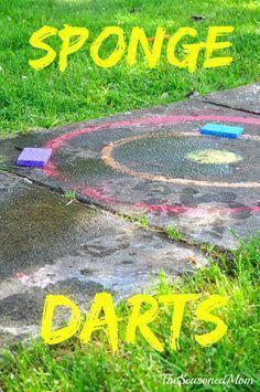 the words sponge darts are written in chalk on concrete next to a sidewalk and grass