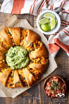 a large pastry with guacamole in the middle and salsa on the side