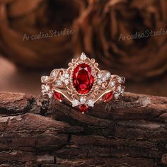 a close up of a ring with a red stone in the middle and white diamonds around it