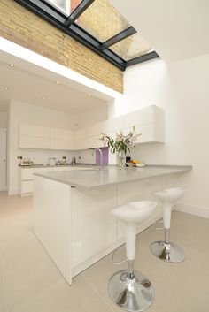 a kitchen with two stools next to an island