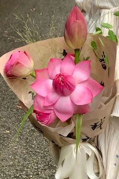 a bouquet of pink flowers sitting on top of a bag