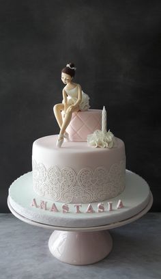 a cake with a woman sitting on top of it