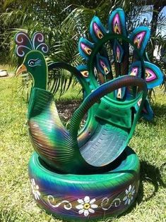 a green bench with peacocks painted on it in the grass next to palm trees