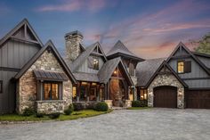 a large stone and wood house with two garages