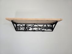 a shelf that has some kind of metal object on it's side and is hanging from the wall