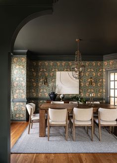 a dining room table with chairs and a chandelier hanging from it's ceiling