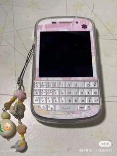 a cell phone with a keychain attached to it's front and side