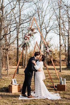 a bride and groom kissing in front of an altar