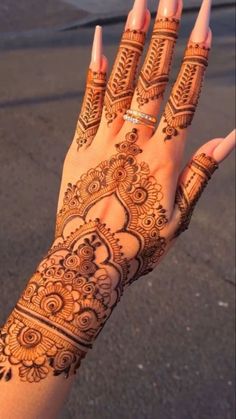 a woman's hand with henna tattoos on it