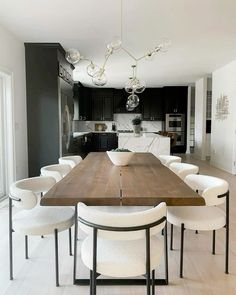 a large wooden table surrounded by white chairs