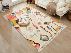 a living room filled with furniture and a rug on top of a hard wood floor