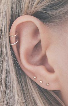 a close up of a person's ear with two piercings on the side