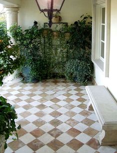 the interior of a house with plants on the wall and tiled floor in front of it